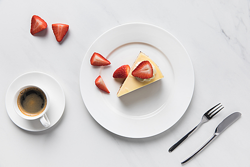 Top view of coffee cup with strawberry cheesecake on plate