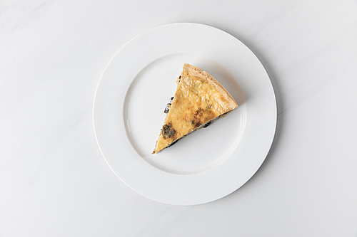 Plate with delicious pie placed on white surface