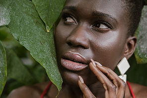 frightened african american girl posing in green garden
