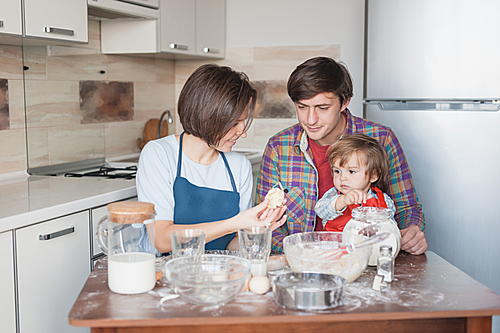 beautiful young family preparing cookies in shape of christmas tree