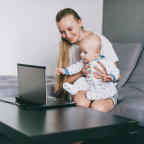 happy young mother and adorable infant child using laptop together