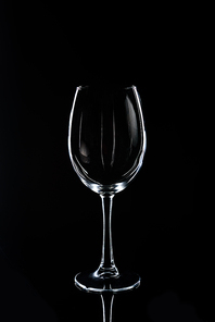one wineglass on black reflecting tabletop