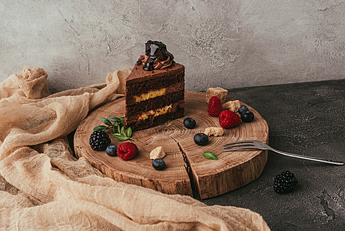 close-up view of sweet tasty chocolate cake with berries on wooden board