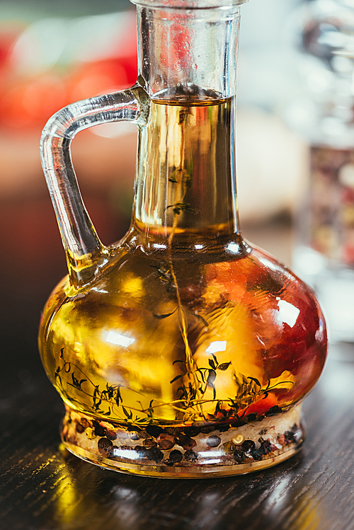 close-up view of healthy olive oil with spices in glass bottle