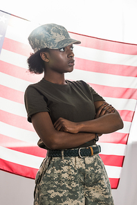 Young african american female soldier in camouflage clothes in front of us flag