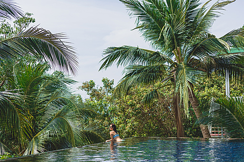 20대 여성 in bikini lying in swimming pool with beautiful nature around