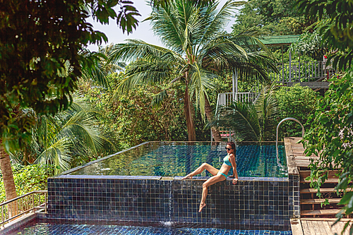 beautiful 20대 여성 in bikini relaxing on poolside at tropical resort