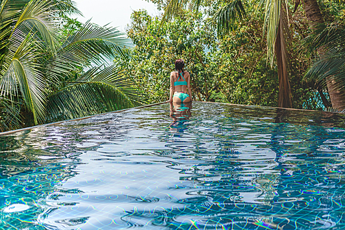 rear view of seductive girl in bikini in swimming pool