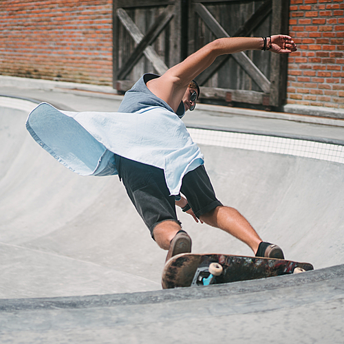 young skater skating on longboard at skatepark