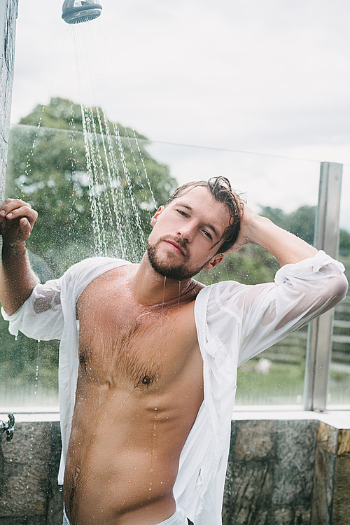 sexy handsome man taking shower outdoors in Bali, Indonesia
