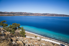 beautiful landscape with calm blue water and rocky coast, salda golu, turkey