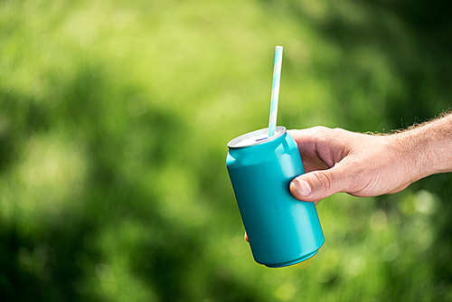 cropped shot of man with drink in blue can with straw in hand