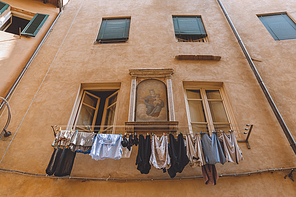 laundry hanging outside buildings with icon on wall in Pisa, Italy