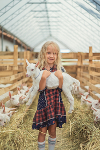 happy child holding goat at farm and 