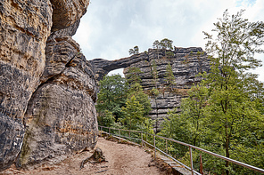 pathway and railing between beautiful pravcicka brana rock formation in Czech Republic