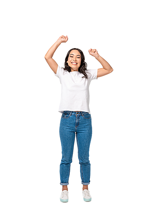 Happy asian smiling girl in white t-shirt and blue jeans standing with hands up isolated on white