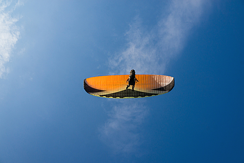 person flying on paraplane, blue sky on background
