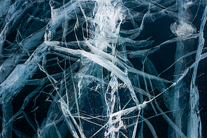 close up view of cracks of frozen water in winter