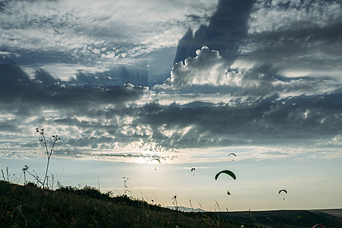 Parachutists gliding in blue sky over scenic landscape of Crimea, Ukraine, May 2013