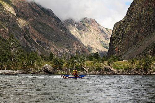 people on kayaks rafting on mountain river and beautiful landscape, Altai, Russia