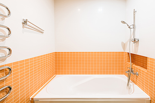 close up view of bath tube in bathroom in orange and white colors