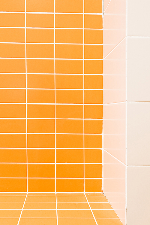 close up view of white and orange tile in bathroom
