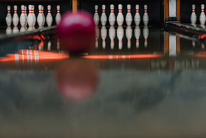 red bowling ball rolling to pins by alley
