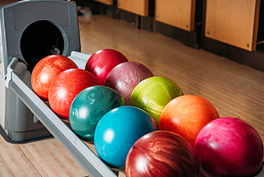 close-up shot of stand with colorful bowling balls in club