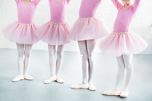 cropped shot of kids in pink tutu skirts practicing ballet together