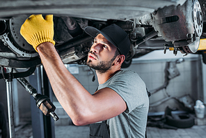 male mechanic fixing a car in auto repair shop