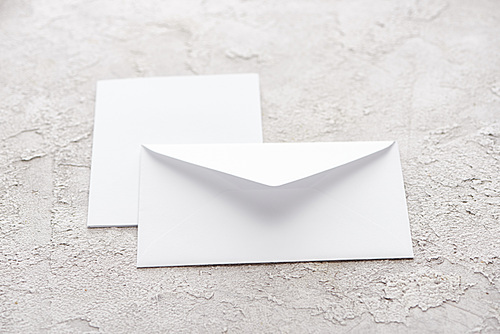 white paper envelope and card on grey textured surface