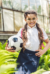 beautiful schoolgirl with soccer ball in garden 