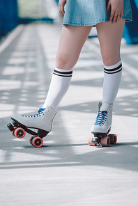 partial view of woman in white high socks with black stripes and retro roller skates