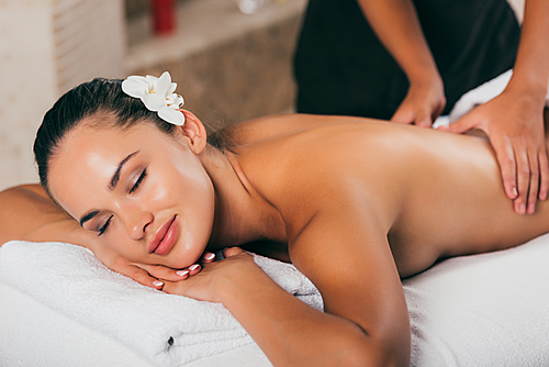 smiling woman having massage therapy at spa salon