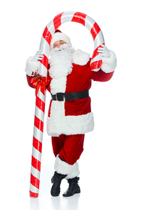 happy santa claus standing with big christmas candy cane isolated on white
