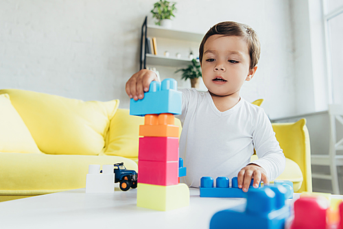 toddler playing with colorful constructor blocks at home