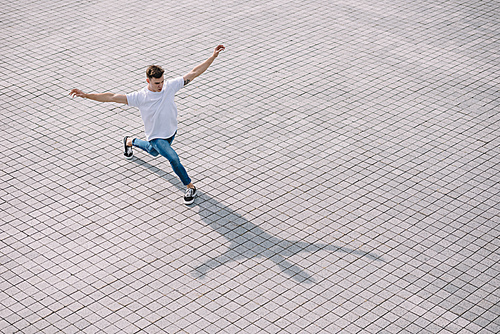 high angle view of handsome young man performing contemporary dance on street