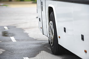 selective focus of white travel bus wheel at urban street