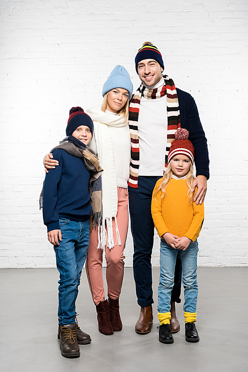 smiling family in winter clothes hugging and  on white background