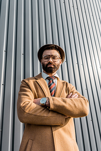 low angle view of confident businessman standing with arms crossed