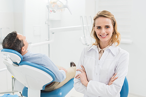 Female doctor with folded arms in modern dental clinic