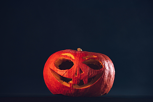 Spooky Halloween carved pumpkin, jack o lantern, on black background