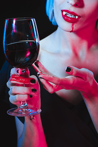 cropped view of vampire holding wineglass with blood isolated on black