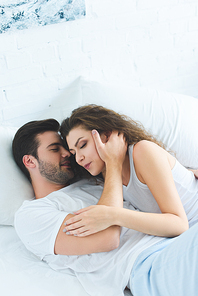 high angle view of beautiful young couple in love lying together in bed