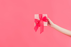 cropped shot of woman holding gift isolated on pink