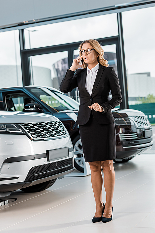 유토이미지 | businesswoman in formal wear talking on smartphone in dealership salon