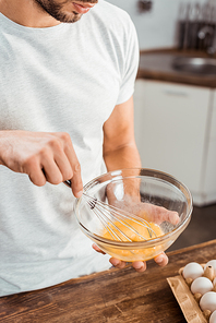 cropped shot of young man whisking omelette in bowl at morning
