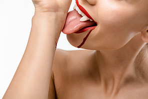 cropped shot of naked girl with vampire teeth licking blood from hand isolated on white