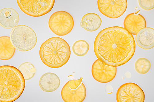 bright orange and lemon slices on grey background with water bubbles