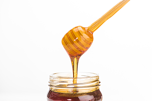 wooden honey dipper with dripping delicious honey isolated on white